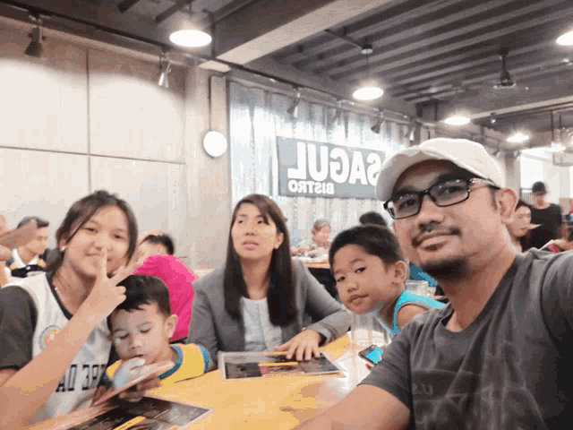 a group of people sitting at a table in front of a sign that says juaa2