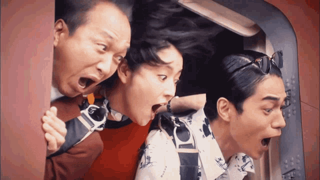 two men and a woman are looking out of a doorway with their mouths wide open