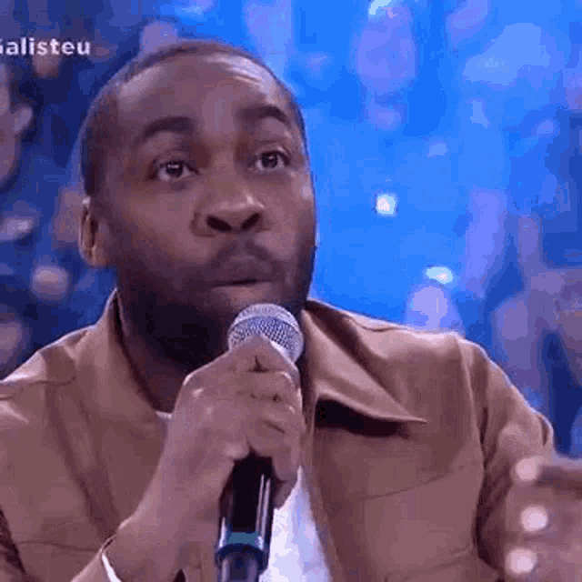 a man is holding a microphone in his hand and making a funny face .