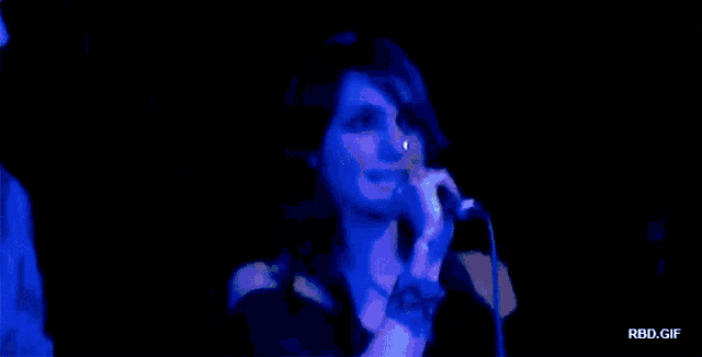 a man in a joe boxer shirt stands next to a woman singing into a microphone on stage