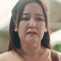 a close up of a woman 's face making a sad face .