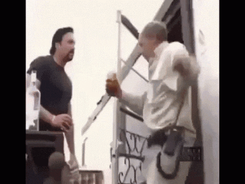 two men are standing next to each other in front of a trailer .