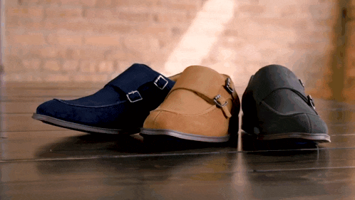 three pairs of shoes are sitting on a wooden floor
