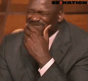 a man in a suit and tie is laughing with a sb nation logo behind him .