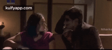 a man and a woman are fighting each other in a dark room .
