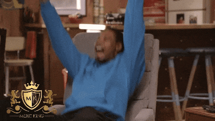 a man in a blue sweater sits in a chair with his arms in the air and a merit king logo in the corner