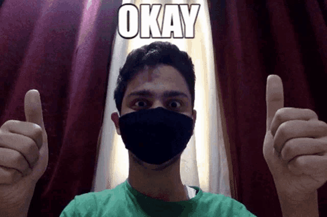 a man wearing a mask is giving a thumbs up and the word okay is above him