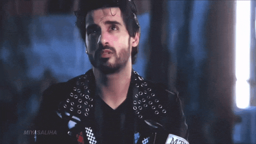 a man with a beard is wearing a black jacket that says miyasaliha on it