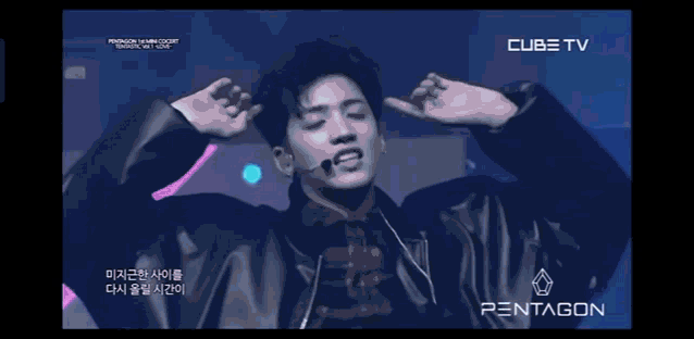 a group of young men are performing on a stage in front of a sign that says pentagon