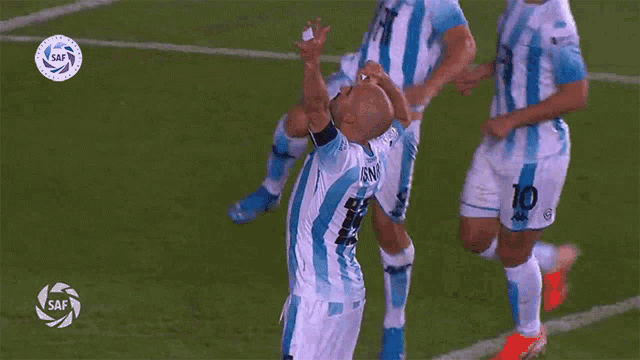 a group of soccer players are celebrating a goal with the word saf on the bottom