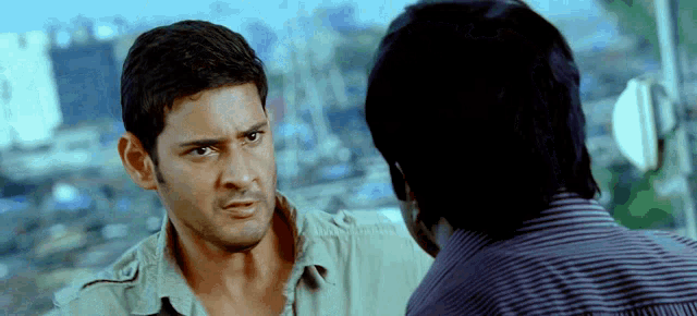 a man in a green shirt is talking to another man