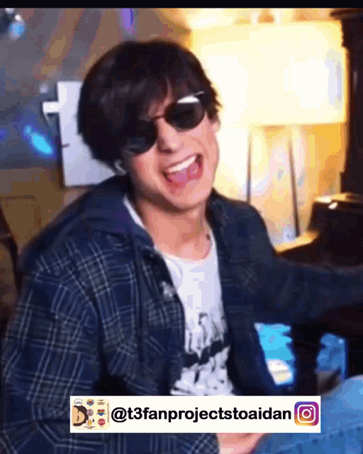 a young man wearing sunglasses and a plaid shirt is smiling with the hashtag t3fanprojectstoaidan below him