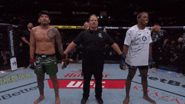 a referee stands between two fighters in a ufc fight