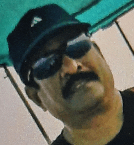 a man with a mustache wearing sunglasses and a baseball cap with the letter f on it