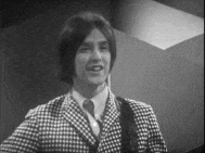 a man in a plaid suit and tie is smiling in a black and white photo