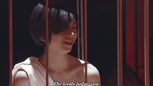 a woman in a white dress is behind bars and says `` the gods judge you . ''
