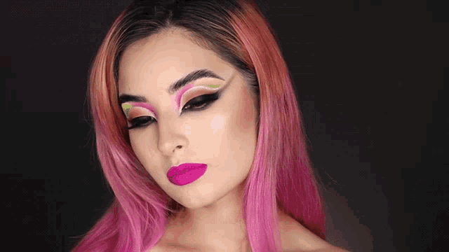 a woman with pink hair is wearing a neon makeup look