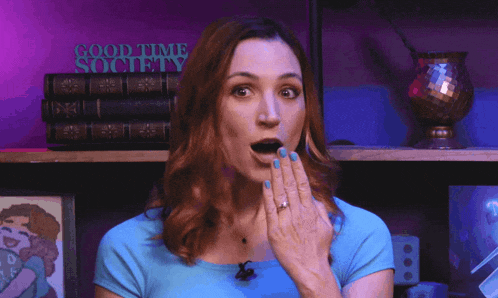 a woman blows a kiss in front of a good time society sign