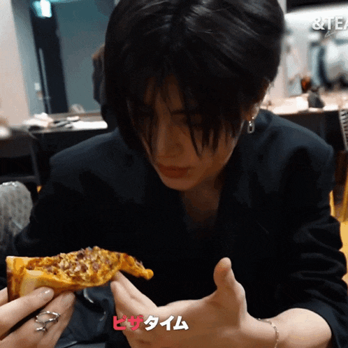 a person holding a slice of pizza with a sign that says tea