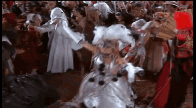 a woman in a white dress with black polka dots is dancing in a crowd of people