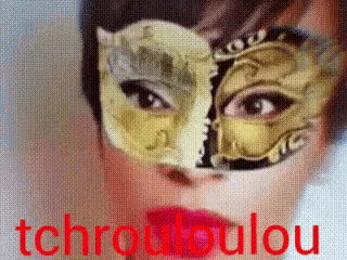 a close up of a woman wearing a mask with the words tchroudoulou in red behind her