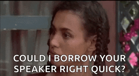 a woman is talking to another woman and asking her if she could borrow her speaker right quick .