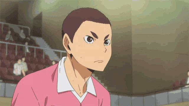 a man in a pink shirt with a white collar is looking at the camera