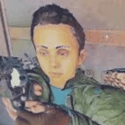 a man is holding a gun in his hand and looking at the camera .