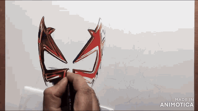 a person is drawing a mask on a piece of paper with the words made in animotica on the bottom right