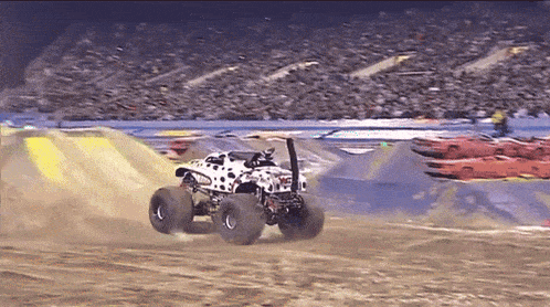 a dalmatian monster truck is driving on a dirt road
