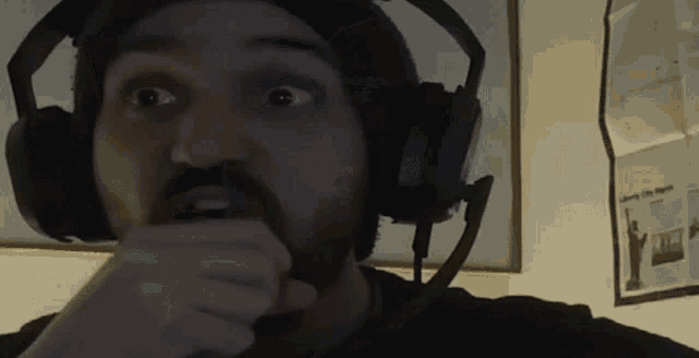 a man with a beard wearing headphones looks surprised