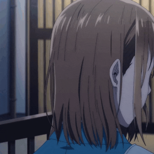 a close up of a girl 's ear with a blue shirt