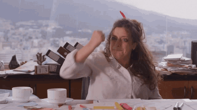 a woman sitting at a messy desk with a calendar that says 13 on it