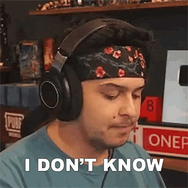 a man wearing headphones and a headband is making a funny face and saying `` i don t know '' .