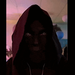 a person wearing a hooded sweatshirt with a necklace around their neck