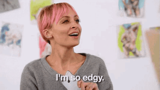 a woman with pink hair is laughing and saying `` i 'm so edgy '' in front of paintings .