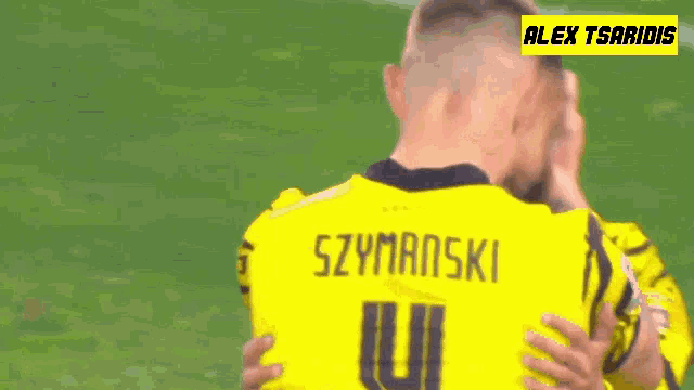 two soccer players are hugging each other and one of them has the name szymanski on his jersey