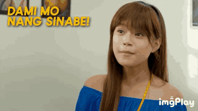 a woman in a blue off the shoulder top with the words dami mo nang sinabe