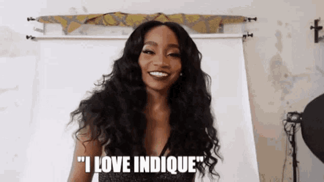 a woman with long hair is smiling and saying " i love indicue "