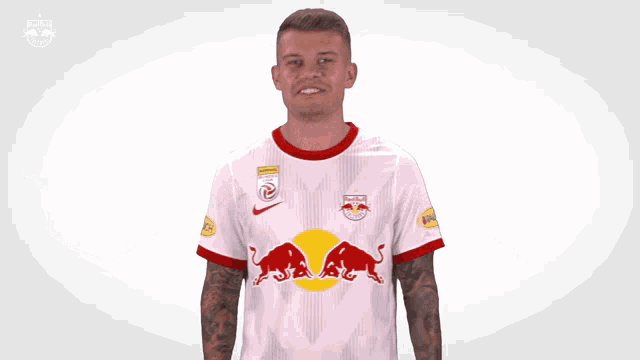 a man wearing a white jersey with a red bull on the front