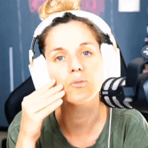 a woman wearing headphones and a green shirt is making a face