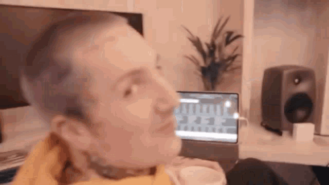 a man is sitting in front of a laptop computer in a room .