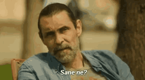 a man with a beard is sitting in a chair and talking to someone in a language other than english .