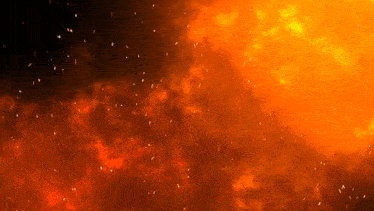 a fire with sparks flying in the air on a dark background