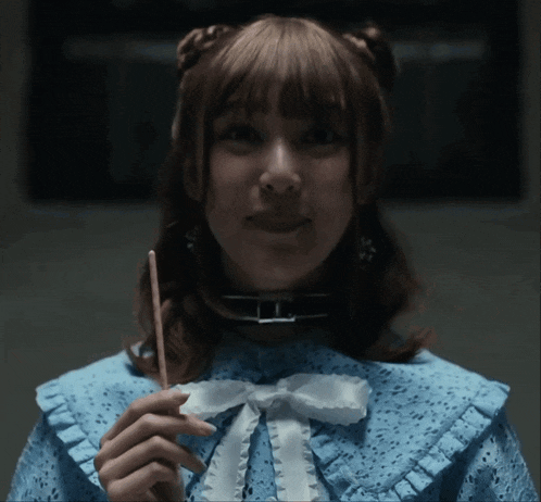 a woman in a blue dress holding a stick