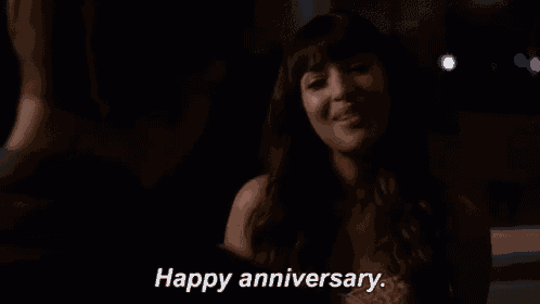 a woman is smiling while a man says happy anniversary