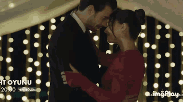 a man and woman are dancing in front of a sign that says ' oyunu ' on it