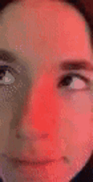 a close up of a person 's face with red cheeks and a red background .