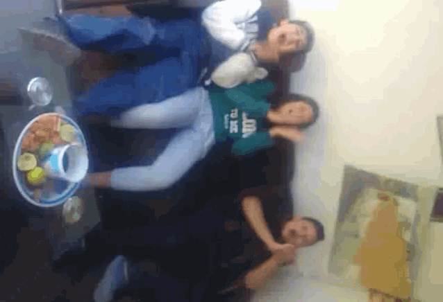 three people are laying on a couch and one of them is wearing a green shirt that says ' atlanta ' on it