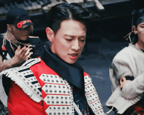 a man wearing a red and white jacket with a black scarf around his neck and a hat that says osiris on it
